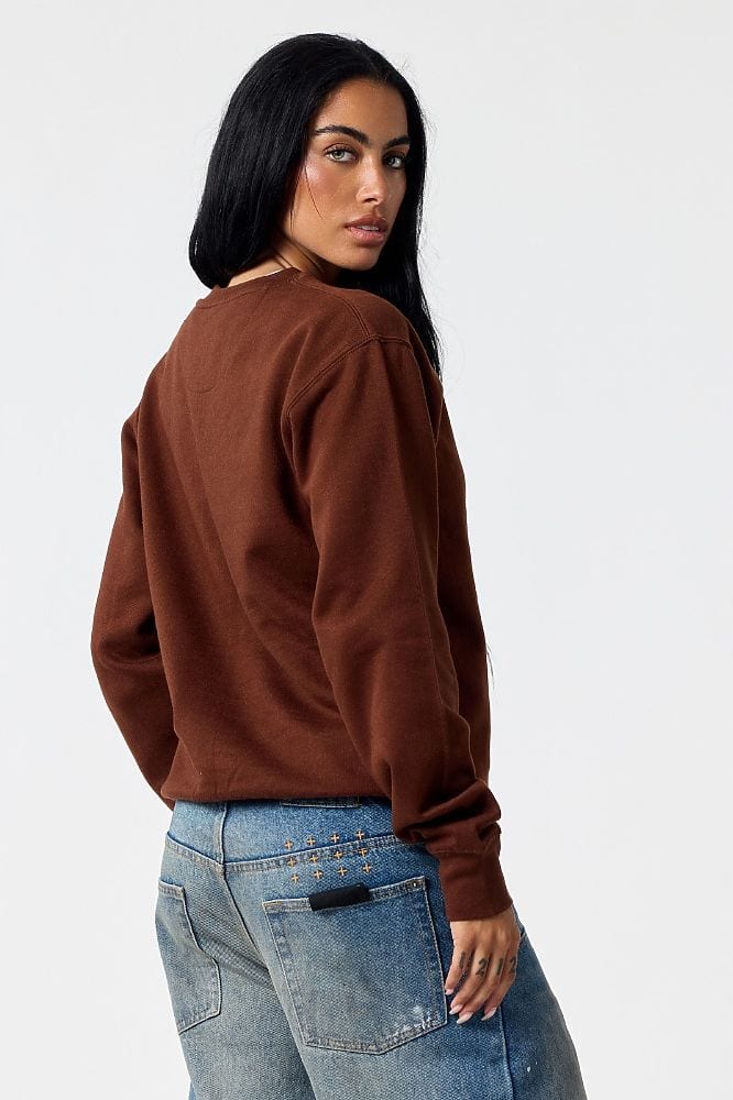 A woman in the 103 essential crew sweatshirt in chocolate, seen from behind